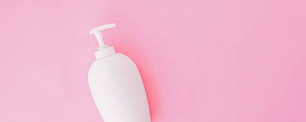 Garrafa de sabão líquido antibacteriano e desinfetante de mão sobre fundo rosa, produto de higiene e cuidados de saúde
 - Foto, Imagem