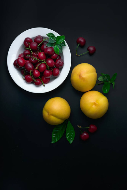 Персики і вишні на білій тарілці
 - Фото, зображення