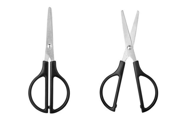 Two silver metal open and closed scissors with black plastic handles on white background isolated close up, steel cutting tool for paper, fabric clippers, haircut shears, tailor pair of scissors - Photo, Image