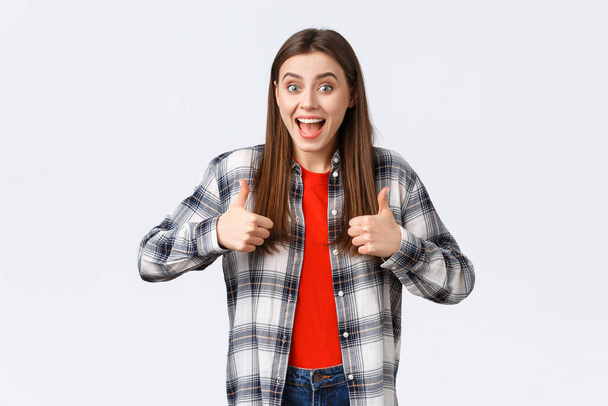 Lifestyle, different emotions, leisure activities concept. Super good idea. Cheerful excited pretty woman in casual checked shirt, thumbs-up and smiling, approving, like idea or support your choice - Foto, Imagem