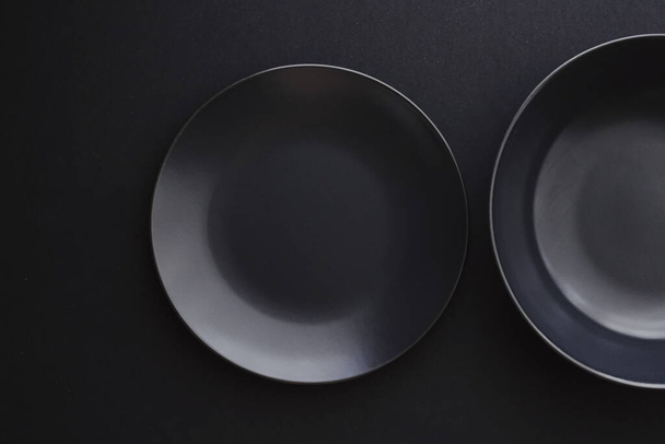 Üres tányérok fekete alapon, prémium mosogatószerek ünnepi vacsorához, minimalista design és diéta - Fotó, kép