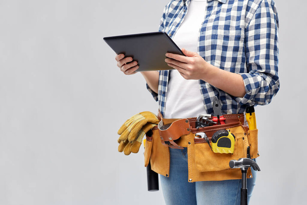 woman or builder with tablet pc and working tools - Photo, image