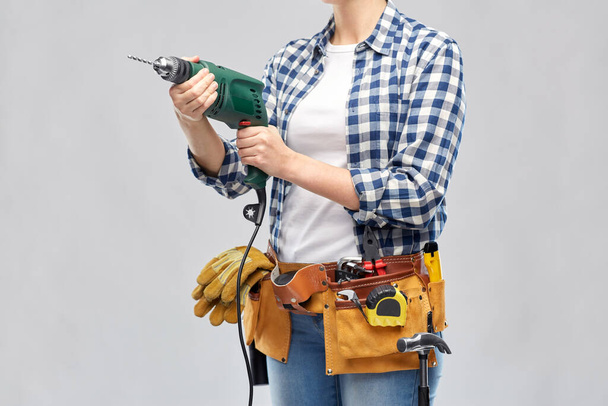 woman or builder with drill and work tools - Фото, изображение