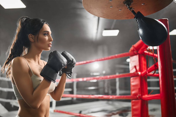 Female boxer hitting small punching bag. - Фото, изображение