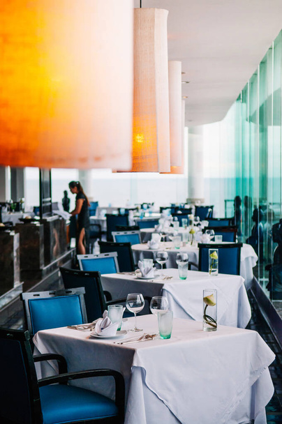 AGO 6, 2014 Hua Hin, TAILANDIA - Hotel de lujo de estilo contemporáneo asiático restaurante mesa con glaas de vino, jarrones de flores de loto y lámparas, elegancia, ambiente cálido
 - Foto, Imagen