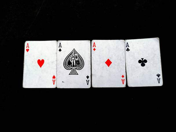 Satz von vier Assen, die Karten in Farbe spielen. Gewinnende Pokerhand isoliert auf schwarzem Hintergrund - Foto, Bild
