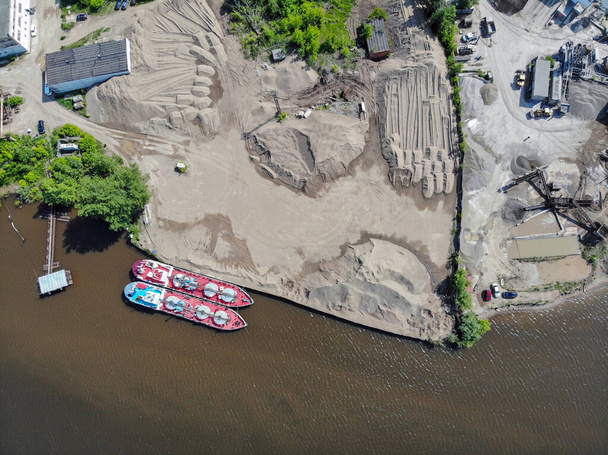 Vista aérea de una planta de procesamiento de arena y grava cerca de un río. Extracción, tratamiento y venta de todo tipo de arena natural y artificial
. - Foto, imagen