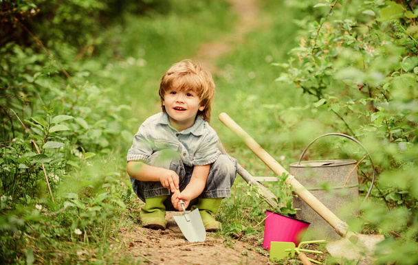 farming and agriculture cultivation. small kid gardener planting a flower. human and nature. earth day. Eco life. summer activity. happy child farmer use garden shovel, spring. Enjoying spring day - Фото, зображення