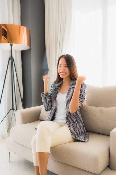 Portrait beautiful young asian women happy smile relax sitting on sofa chair in living room interior - Foto, Imagem