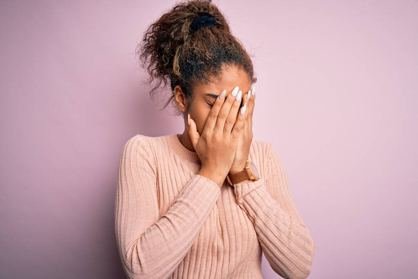Young beautiful african american girl wearing casual sweater standing over pink background with sad expression covering face with hands while crying. Depression concept. - Foto, immagini