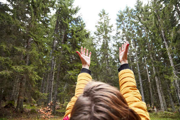 Γυναίκα στη φύση κρατά τα χέρια στον αέρα και απολαμβάνοντας καλές φυσικές δονήσεις. - Φωτογραφία, εικόνα