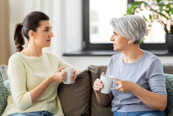 senior mother and adult daughter drinking coffee - Photo, image