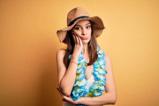 Fiatal gyönyörű barna nő nyaralni visel fürdőruha és hawaii virágok lei gondolkodás fáradt és unatkozik a depresszió problémák keresztbe karok. - Fotó, kép