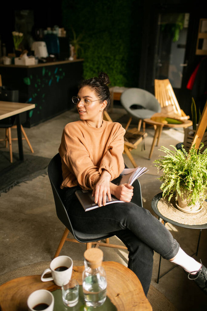  Девушка-блоггер с чашкой кофе в кафе с журналом
 - Фото, изображение