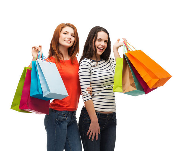 Two smiling teenage girls with shopping bags - Fotoğraf, Görsel
