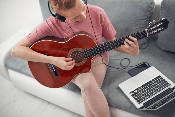 Gitarist dizüstü bilgisayarda internet video dersleri ve özel dersler izliyor.. - Fotoğraf, Görsel
