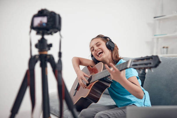 Дитячий гітарист робить відео уроки та навчальні посібники для веб-сайтів у відеоблозі
. - Фото, зображення