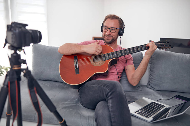 Guitarist making video lessons and tutorials for internet vlog website classes. - Фото, изображение