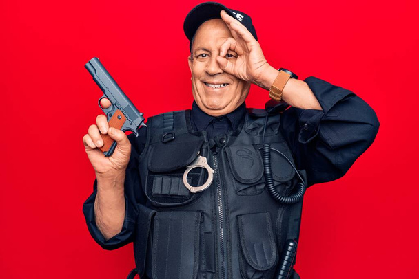 Старший мужчина с седыми волосами, в полицейской форме, держит пистолет, улыбается счастливо, делает хорошо знак с рукой на глазу, глядя сквозь пальцы
  - Фото, изображение