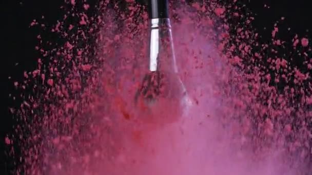 Beauty concept. Make up brush with powder splashes on a black background - Filmagem, Vídeo