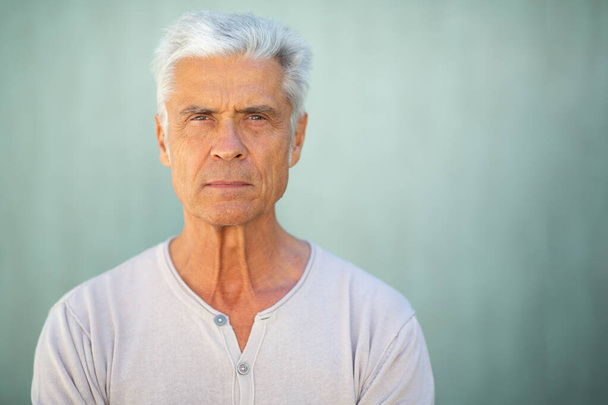 Közelkép portré jóképű idős férfi zöld fal - Fotó, kép