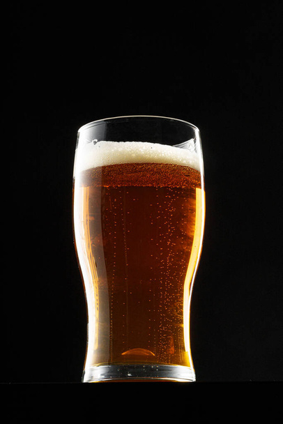 Glas Bier auf schwarzem Hintergrund, Kopierraum - Foto, Bild