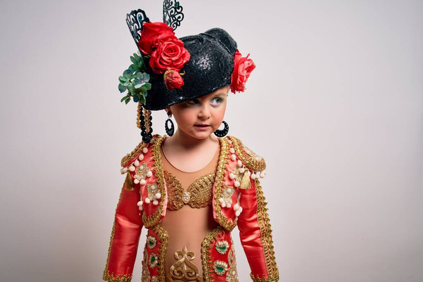 Young little caucasian kid girl wearing  bullfighter traditional folkore spanish suit as carnival costume standing over isolated background - Фото, изображение