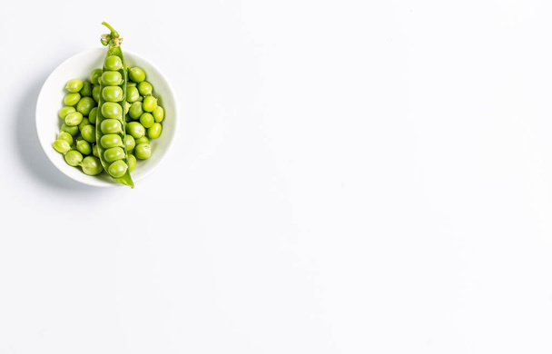 Ripe green peas on a white background, after assembly on the farm - 写真・画像