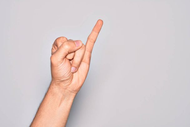 Hand van Kaukasische jongeman met vingers over geïsoleerde witte achtergrond met kleine vinger als pinky belofte inzet, nummer een - Foto, afbeelding
