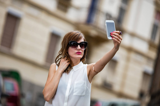 Mulher usando smartphone no meio de uma rua
. - Foto, Imagem