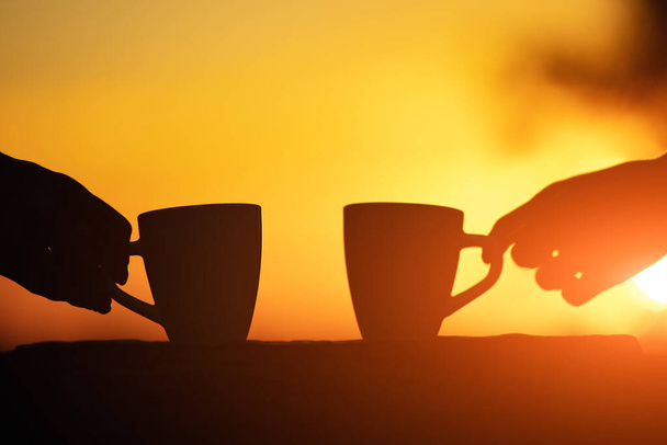Friends drinking coffee in sunrise time, early morning. - Photo, Image