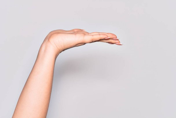 Mano de mujer joven caucásica con palma plana presentando producto, ofrecer y dar gesto, espacio de copia en blanco - Foto, Imagen