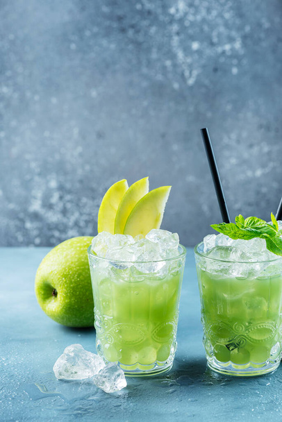 Green cocktail with ice and mint. Bar concept. Apple mojito with mint and ice on the blue background, selective focus image - Foto, Bild