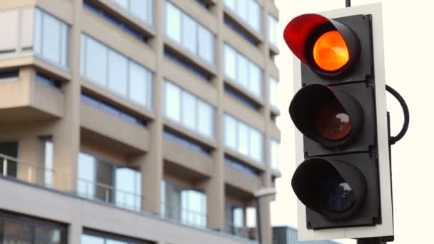 British Traffic Lights zmienia się z czerwonego na zielony Zamknij z zieloną strzałką w górę z bliska na budynku w tle - Materiał filmowy, wideo