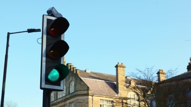 Los semáforos británicos cambian de verde a rojo de cerca en un cruce pelícano contra un cielo azul brillante en un día soleado claro
 - Metraje, vídeo
