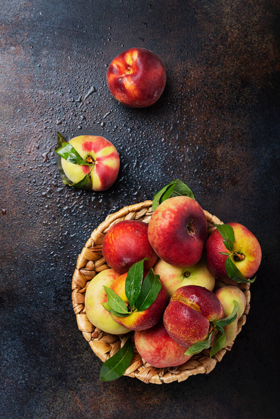 Concept of healthy vegan food. Top down view of sweet peaches with green leaves. Image with copy space for your text - Fotoğraf, Görsel