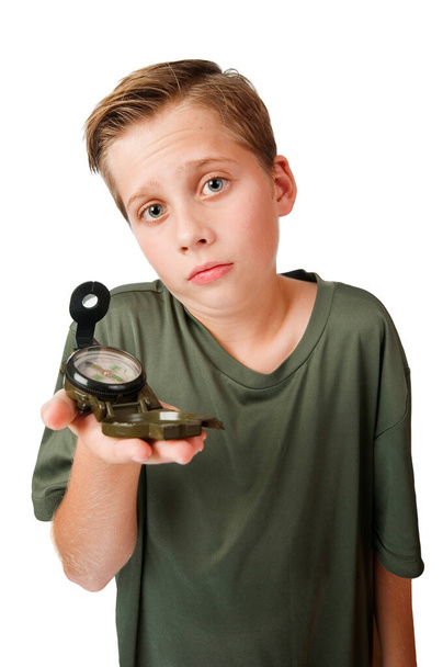 Wide-angle three-quarter view of a 12 year old Caucasian boy with a compass on his right hand looking at the camera at a loss, isolated on white. - Photo, Image