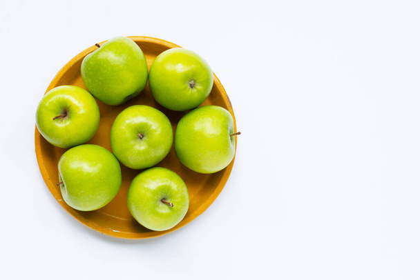 Fresh green apples on yellow plate on white background. Top view - Fotoğraf, Görsel