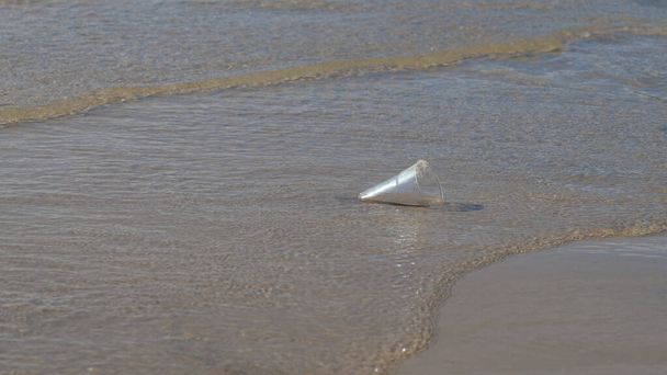 Пластикове скло на піщаному пляжі Сміттєвий пластиковий одноразовий стакан, залишений на піщаному пляжі навколо забруднення морських пластикових відходів
 - Фото, зображення
