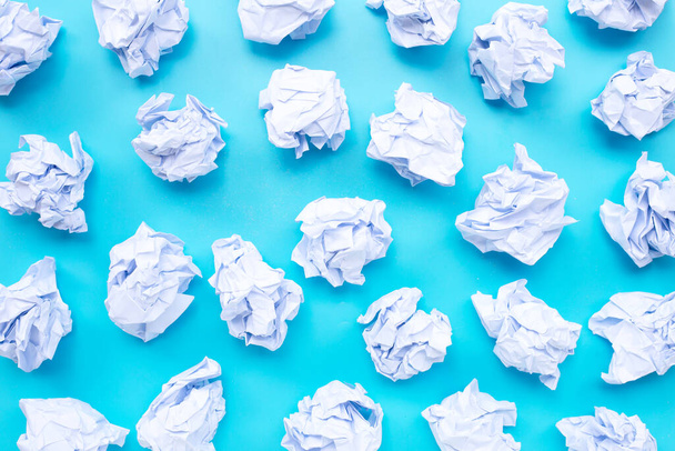 Fehér összegyűrt papírgolyók kék háttérrel. Felülnézet - Fotó, kép