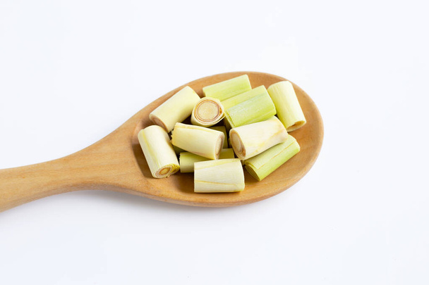 Piezas frescas de limoncillo cortadas en cuchara de madera sobre fondo blanco
. - Foto, imagen