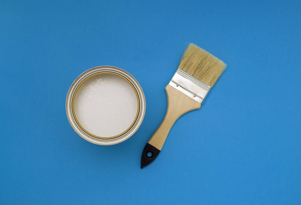 Tools for construction and decoration. A paintbrush and a metal can of paint. Bright background, top view. - Foto, immagini