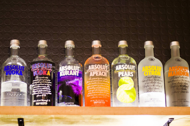 TBILISI, GEORGIE - Bouteille de vodka absolue sur l'étagère du bar. Bouteilles colorées, citron, vanille, classique et autres arômes de vodka. - Photo, image