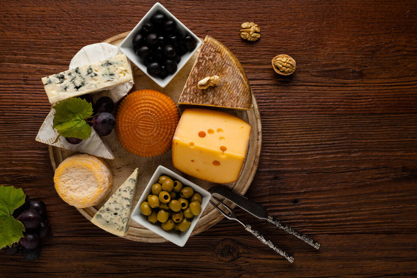 Mezclar el queso sobre tabla de madera con uvas. Vista superior. - Foto, imagen