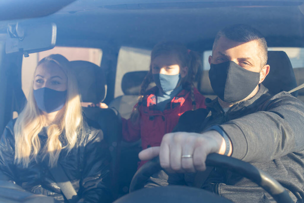Homme portant un masque chirurgical en voiture. Famille portant masque chirurgical en voiture. - Photo, image