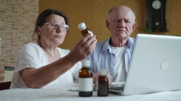Telemedizin, älterer Mann und alte Frau mit Sehbrille beraten Arzt vor Webcam über Medikamente und Tabletten - Filmmaterial, Video