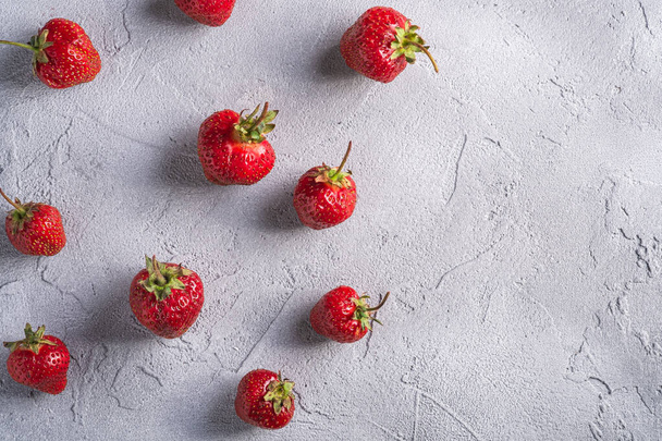 Verse rijpe aardbeien fruit, zomer vitamine bessen op grijze steen achtergrond, bovenaanzicht kopieerruimte - Foto, afbeelding