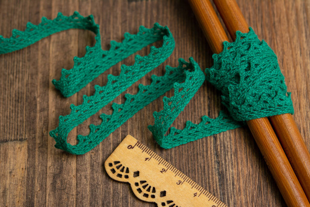 knitted green openwork linen ribbon tapes in rural style of rustics cotton eco natural on wood ground - Photo, Image