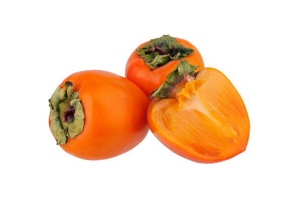 Dwa pomarańczowe owoce persymony lub diospyros i jeden odciąć połowę persymony z zielonymi liśćmi na białym tle odizolowane zbliżenie - Zdjęcie, obraz