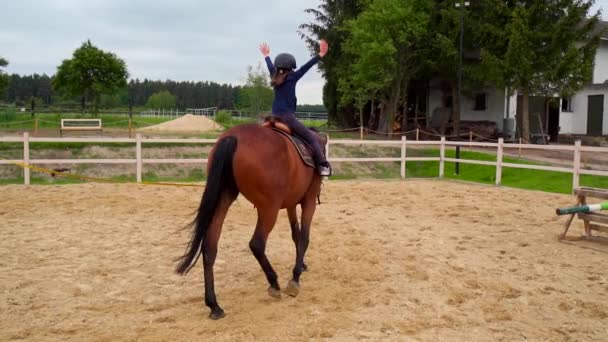 holčička se učí jezdit na koni na ohradě - Záběry, video